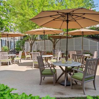 A serene outdoor patio area with tables, chairs, and umbrellas.