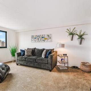 A modern living room with a comfortable sofa, wall art, and decorative plants.
