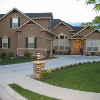 A suburban residential house with a driveway and manicured lawn.