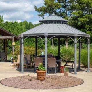 A cozy outdoor gazebo with seating surrounded by a landscaped garden.