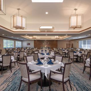 An elegant dining room set up with tables and chairs, featuring sophisticated decor and lighting.