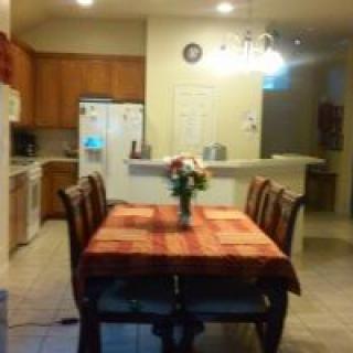 A cozy dining area with a table set and chairs, adjacent to a kitchen.