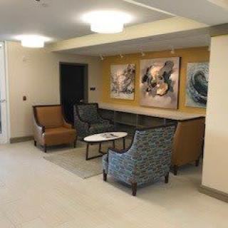 A cozy lobby with comfortable chairs and artwork on the walls.