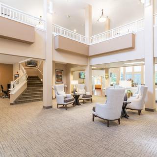 A spacious, modern lobby with comfortable seating and a staircase.