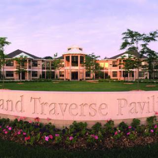 A picturesque view of the Grand Traverse Pavilion, surrounded by lush greenery and vibrant flowers.