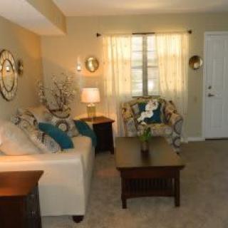 A cozy living room with a sofa, coffee table, and decorative mirrors.