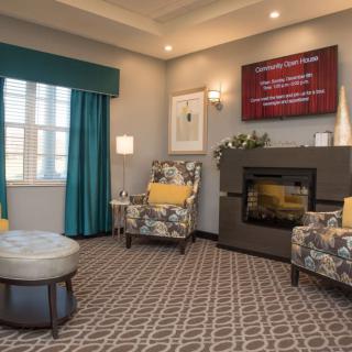 A cozy living room featuring a modern fireplace, patterned armchairs, and elegant decor.