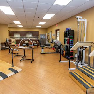 A well-equipped physical therapy room featuring various exercise and rehabilitation equipment.