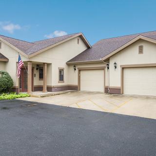 A suburban house with a spacious driveway and multiple garages.
