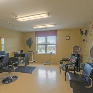 A well-lit hair salon featuring styling stations, mirrors, and seating.