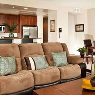 An open-concept living room with a cozy sofa and connected kitchen area.