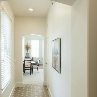 Bright hallway leading to a dining area in a well-lit home interior.