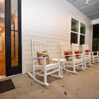 A serene porch featuring inviting rocking chairs, perfect for moments of relaxation.