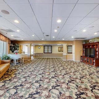 A spacious and well-lit lobby area with floral-patterned carpeting, inviting seating arrangements, and a welcoming atmosphere.