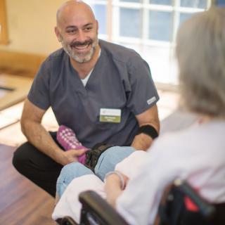 A caregiver engaging in a friendly conversation with an elderly person.
