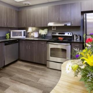 A modern kitchen with stainless steel appliances and a colorful floral arrangement on the counter.