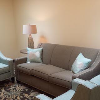 A cozy living room setup featuring a comfortable sofa, matching chairs, and a stylish lamp.