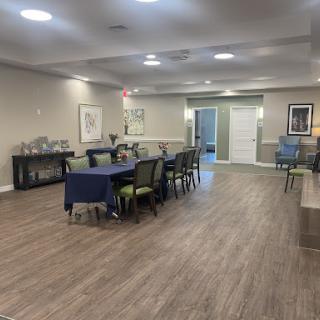 A spacious dining area featuring modern decor and wooden flooring, set up with tables and chairs.