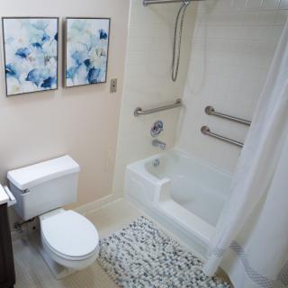 A modern bathroom with wall art and safety features.