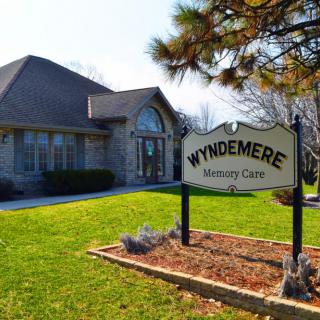 A building with a sign reading 'Wyndemere Memory Care' surrounded by neatly maintained landscaping.