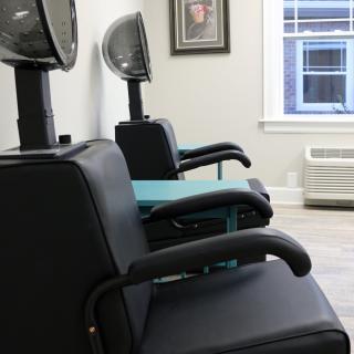 Empty salon chairs with hair dryers in a beauty salon.