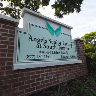 A sign for Angels Senior Living at South Tampa, located on a brick wall.