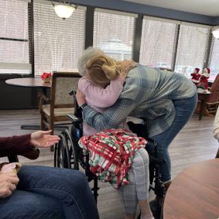 A heartfelt hug shared between two individuals, showcasing the warmth of human connection in a community setting.