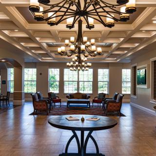 Spacious and elegantly designed lobby with chandeliers and seating area.