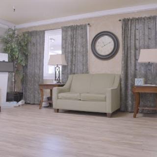 A cozy living room featuring a green sofa, elegant curtains, and stylish decor.