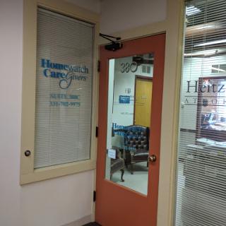 Entrance to an office with a glass door and visible signage.