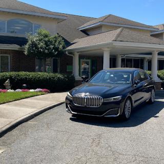 A sleek BMW parked in front of a modern building on a sunny day.
