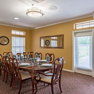 A formal dining room with a long table, elegant chairs, and classic decor.