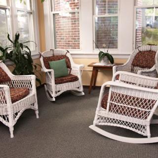 Cozy sunroom with wicker rocking chairs and abundant natural light.