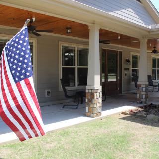 A porch with an American flag and outdoor seating area.