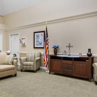 A cozy living room area with sofas, a flag, and decorative items on a wooden cabinet.