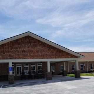A hospital building with a covered entrance under a clear blue sky.