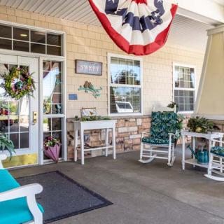 A welcoming porch featuring rocking chairs and patriotic decor.