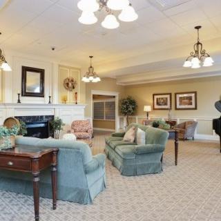 Elegant living room with cozy seating and a grand piano.