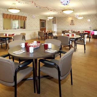 A spacious dining area with neatly arranged tables and chairs, ready for guests.