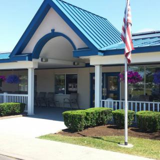 A small restaurant with a blue roof and an American flag in front.