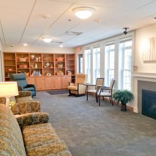 Cozy living space with comfortable seating, a fireplace, and bookshelves.