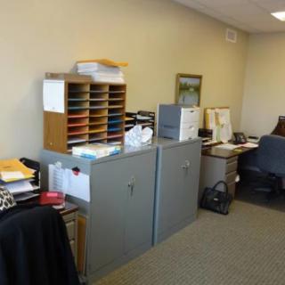 A well-organized office space with desks, filing cabinets, and office supplies.