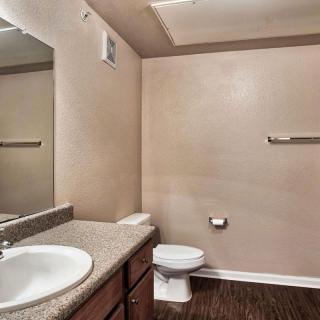 A simple bathroom with a sink, toilet, and mirror.