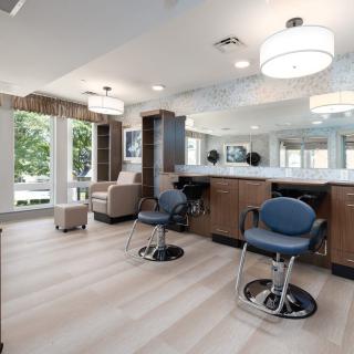 A modern hair salon interior with spacious seating and large mirrors.