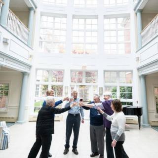 A group of seniors engaging in an indoor group activity at a community center.
