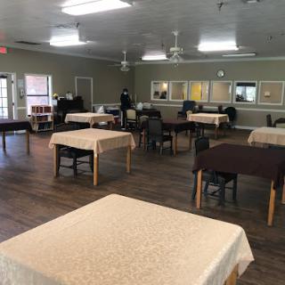 A spacious dining area set up with tables and chairs, ready for an event.