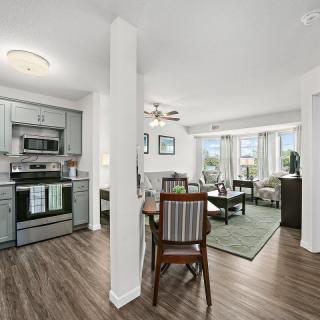 Modern open floor plan with a kitchen, dining area, and living room featuring hardwood floors and contemporary furnishings.
