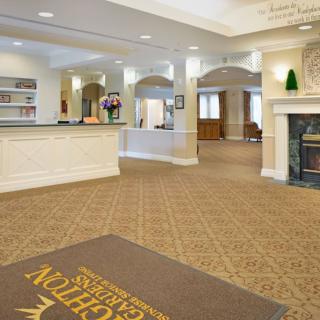 A welcoming hotel lobby with a reception desk and fireplace.