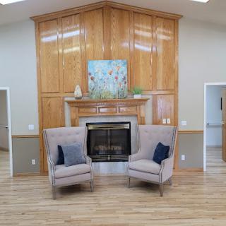 A cozy living room featuring two stylish armchairs and a decorative fireplace.