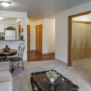 A cozy living room with an open view into the kitchen, featuring comfortable seating and elegant home decor.
